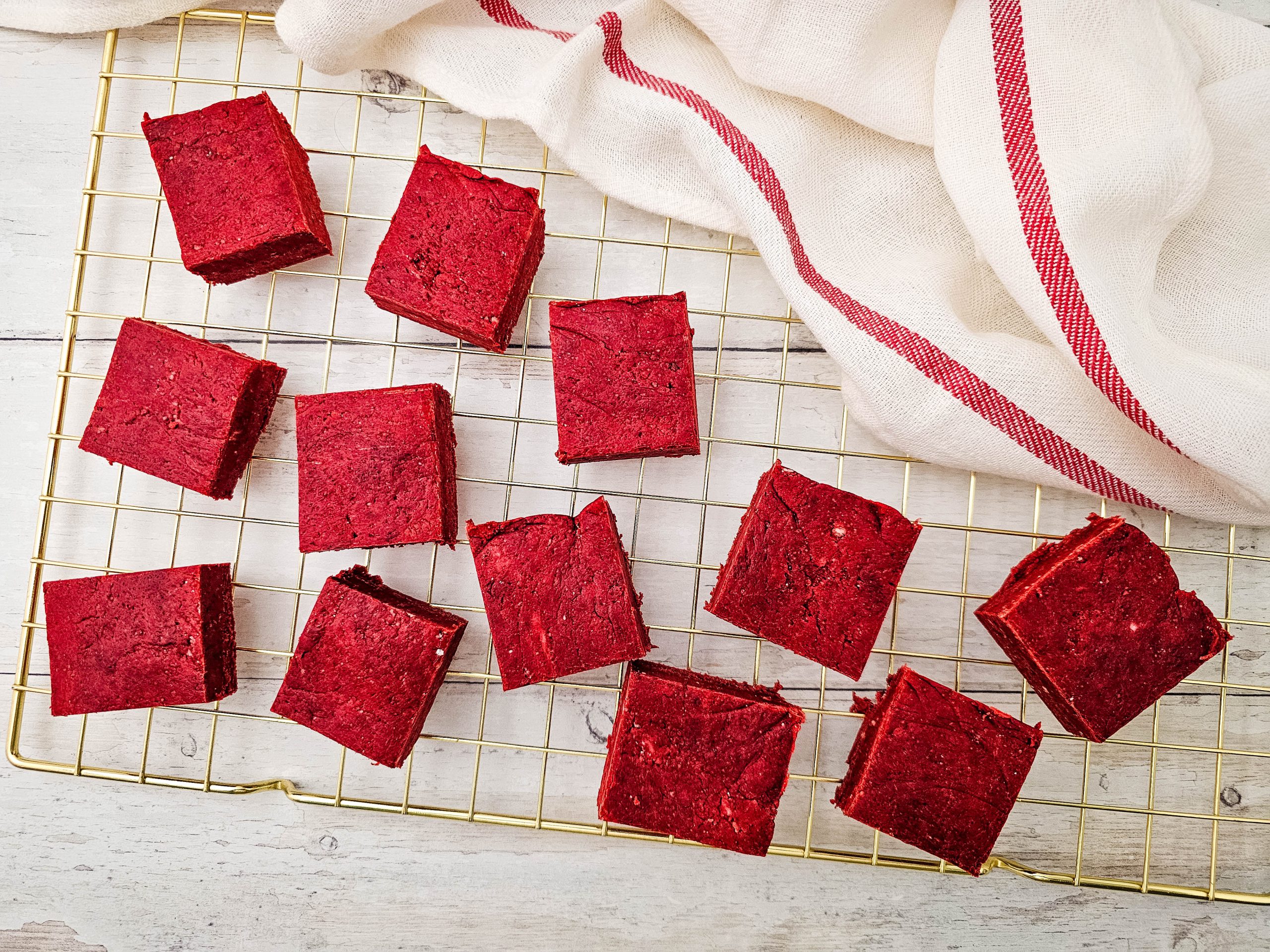 Overhead view of red velvet fudge squares on a cooling rack.