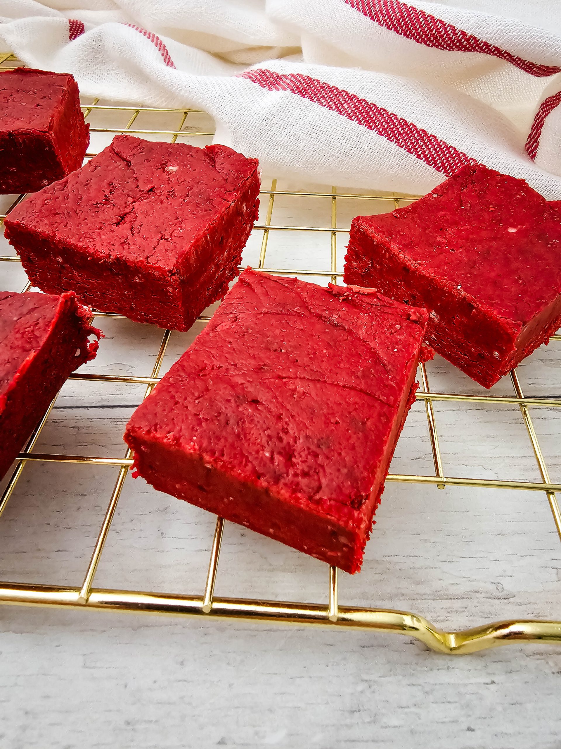 Close up of thick red velvet fudge squares with smooth edges.