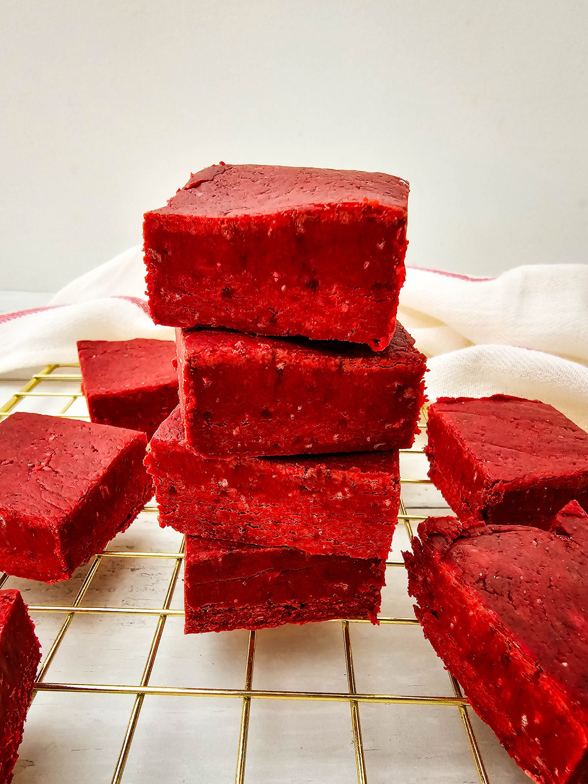 Close up angle of red velvet fudge squares cooling.