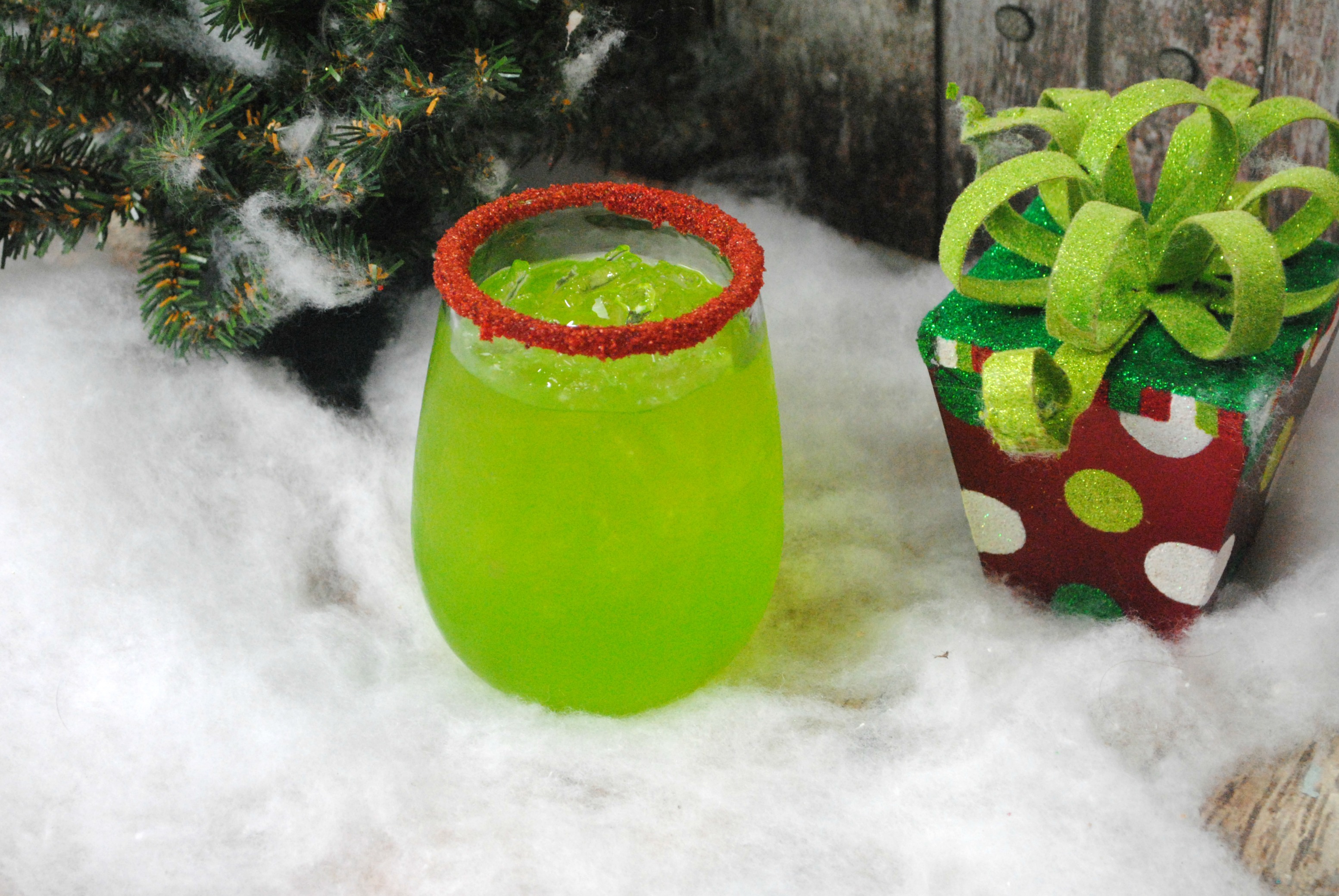 Green cocktail that has red sanding sugar on it. 