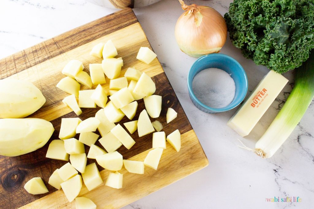 Peeled and cut up potatoes on a wooden cutting board