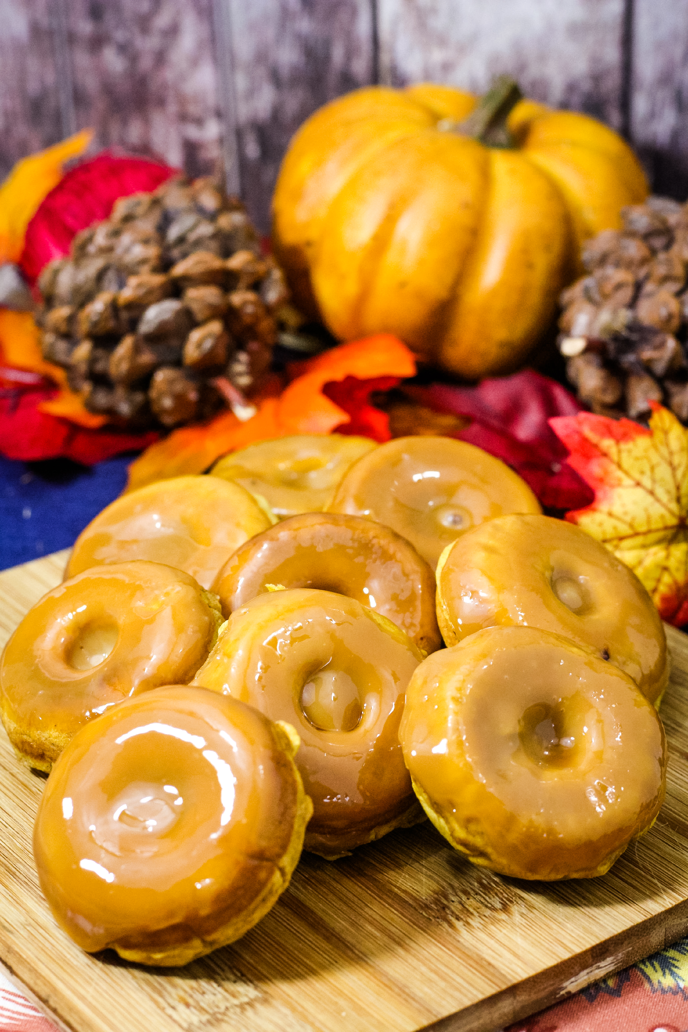 pumpkin spice donuts on a cutting board with a blue background