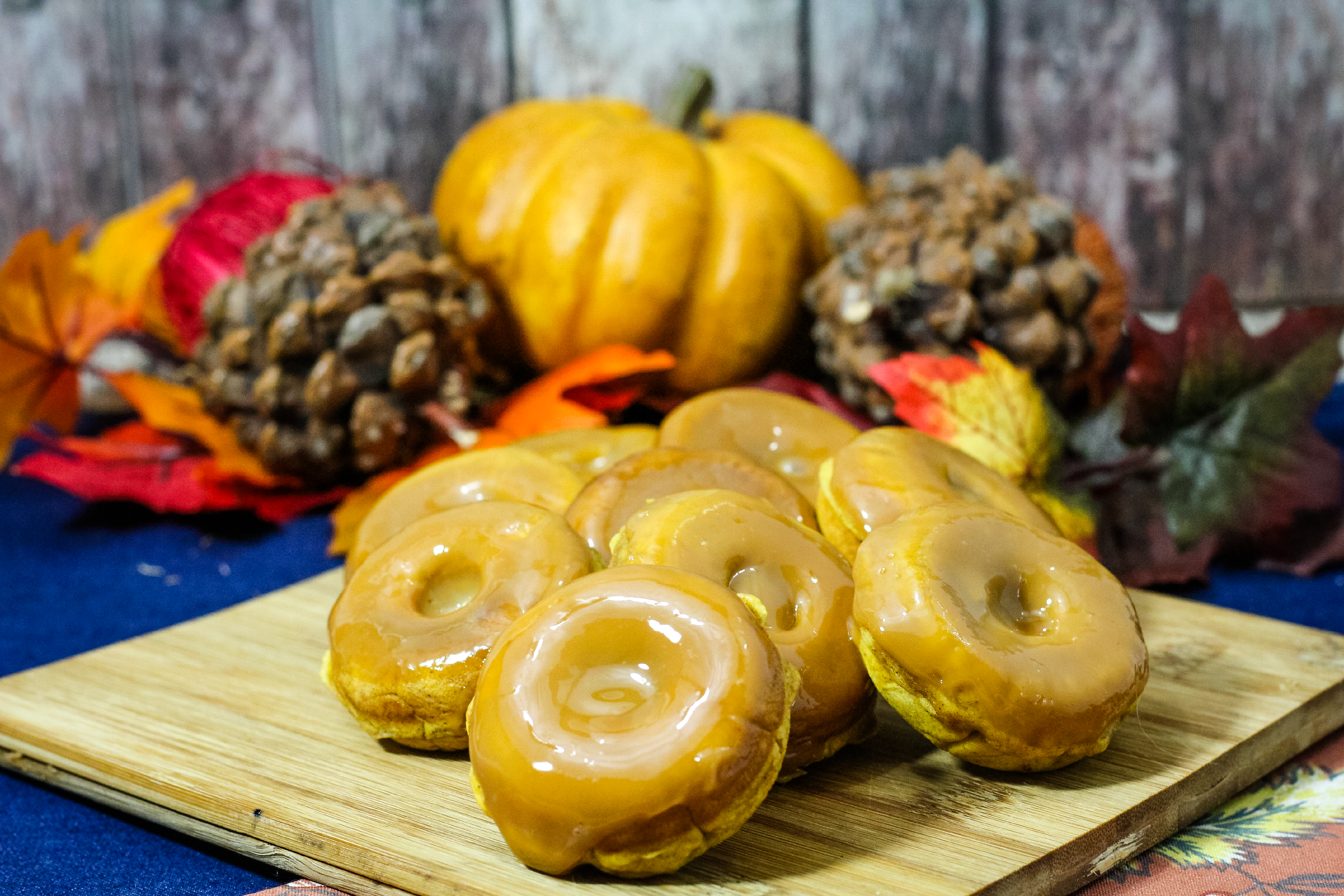 pumpkin donuts on a cutting board with a blue background