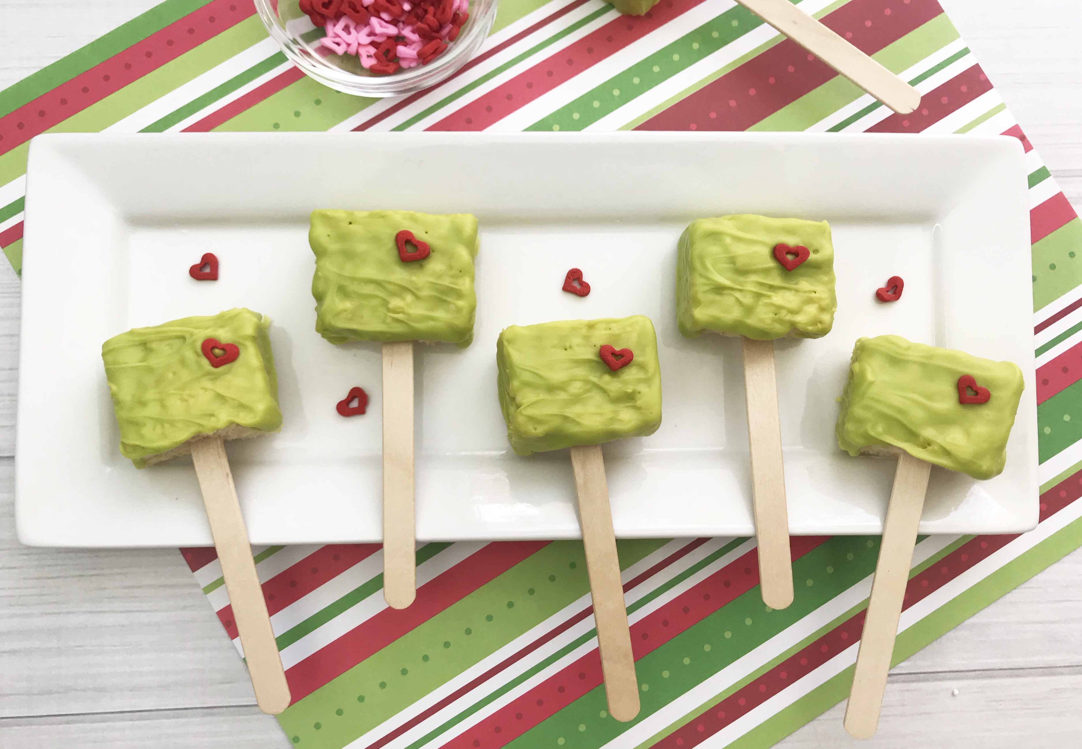 Looking for a fun Grinch treat? These simple to make Grinch Pops, which are Grinch Rice Crispy Treats will be a hit whether you make them for the kids, for a party or for a get-together. I think even the Grinch's heart would grow with these easy Christmas treats.