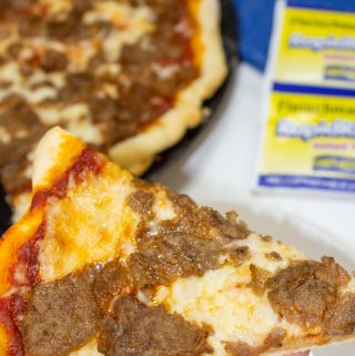 slice of cheesesteak pizza in hand