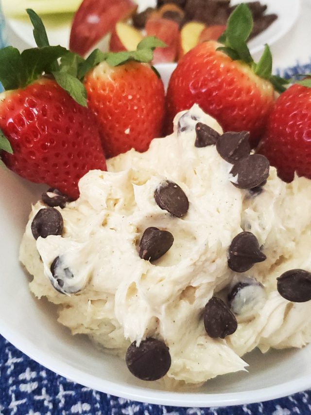 healthy fruit dip on a blue mat with rx nut butter next to it with strawberries in the bowl