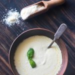 Weight Watchers Alfredo Sauce in a bowl with parmesan cheese on the table