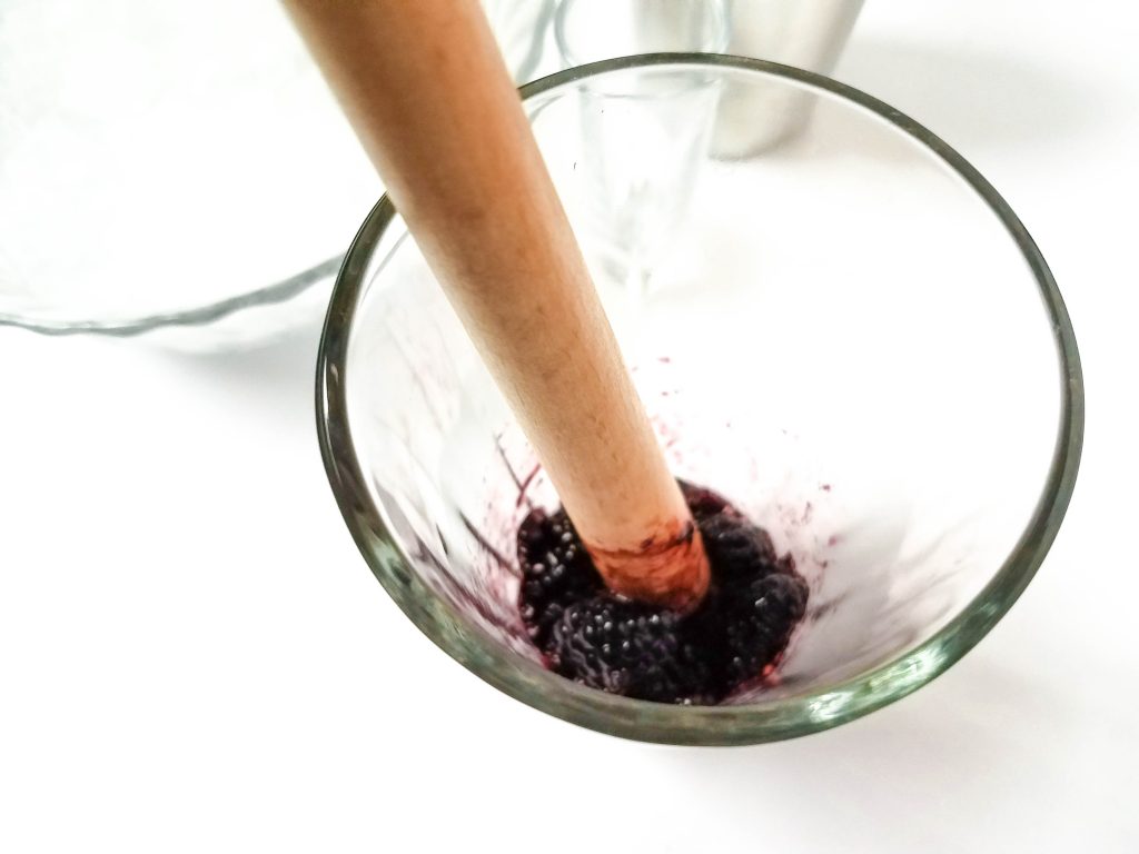 blackberries muddled in a glass