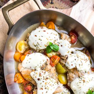Mozzarella Stuffed Chicken Breast with vegetables in a skillet