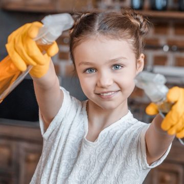 young girl holding spray bottles