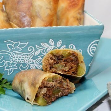 philly cheesesteak eggroll on a blue plate