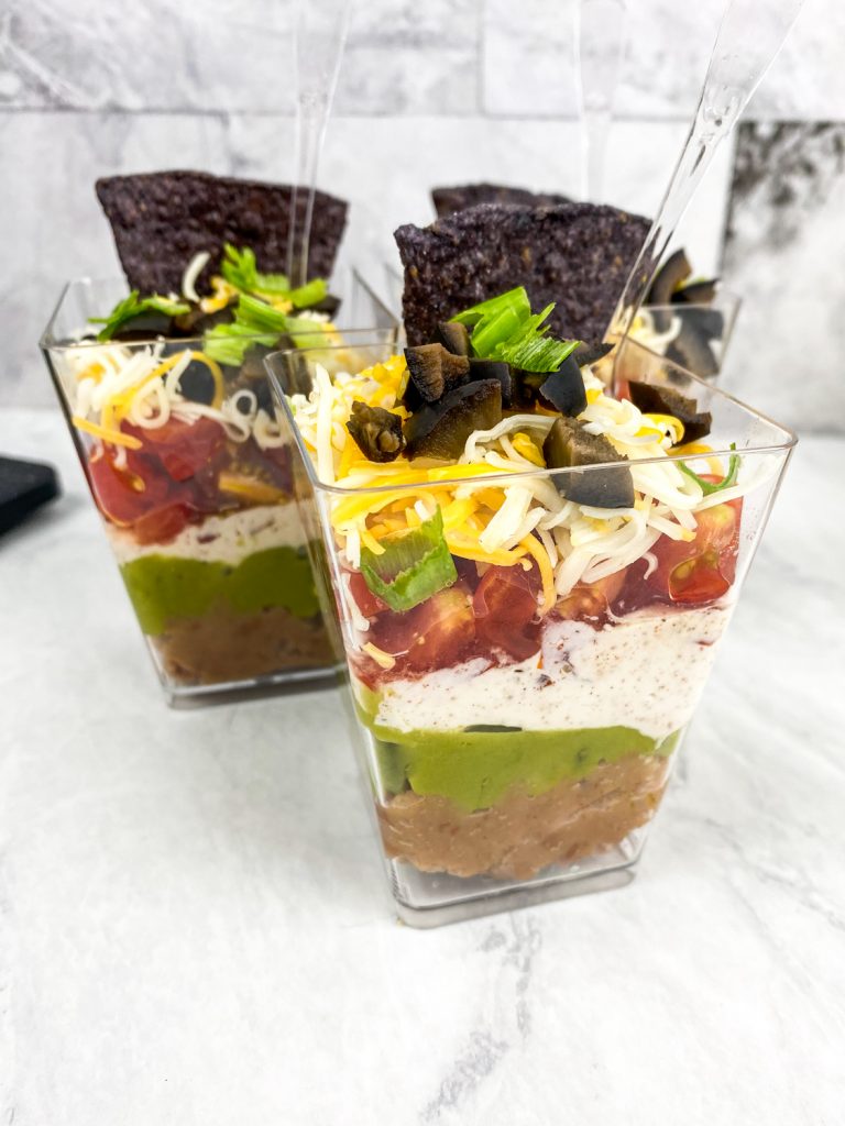 7 layer dip cups together on a white tray