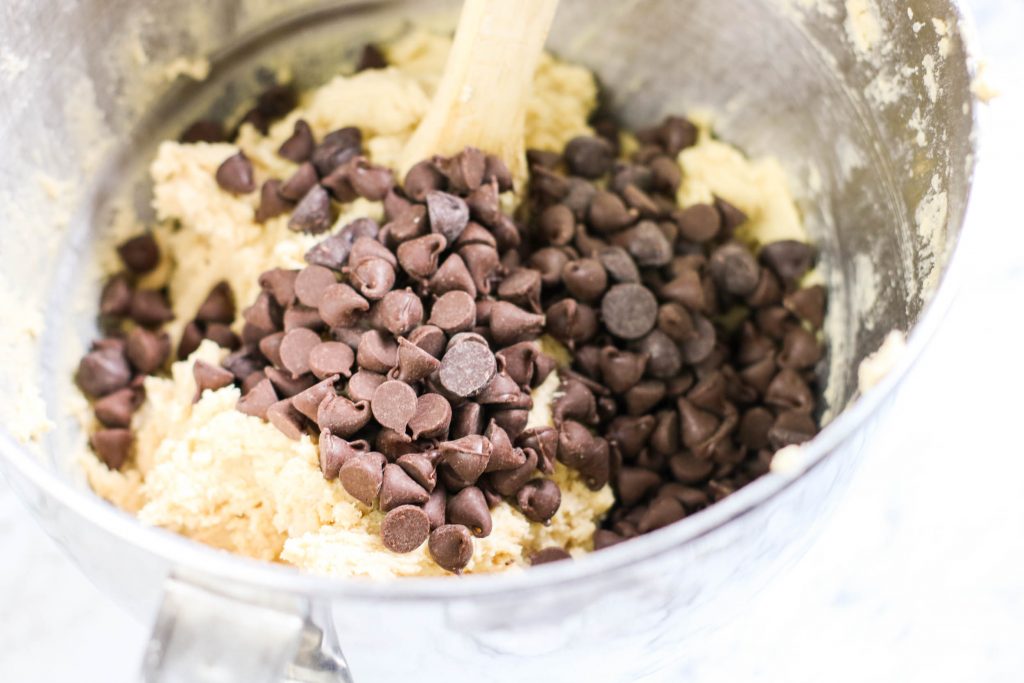 Adding chocolate chips into the cookie batter