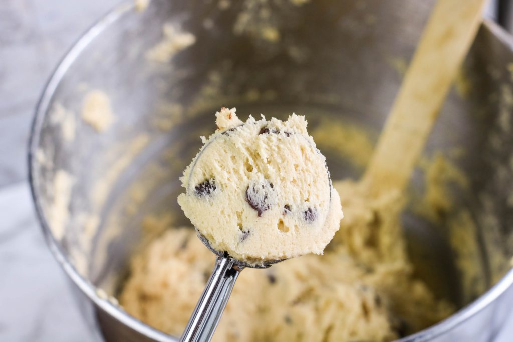 Scooping out the chocolate chip cookie dough to put on a baking sheet