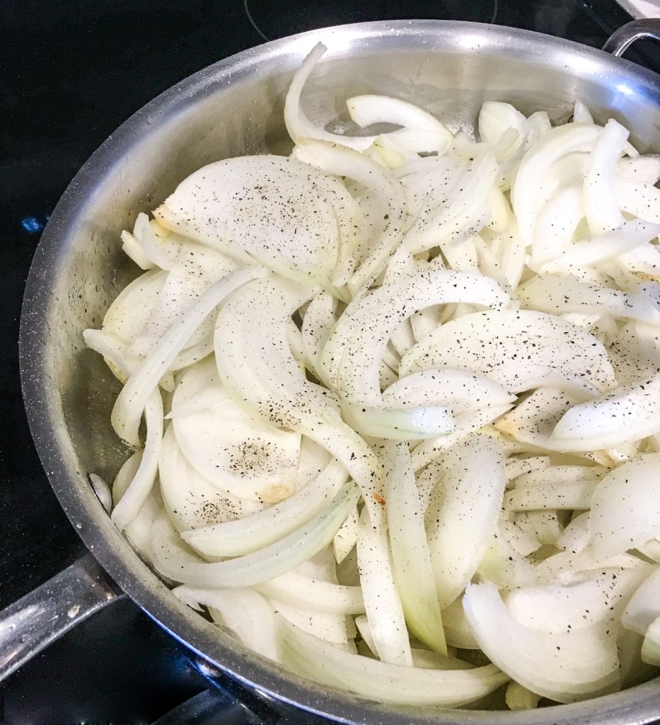 Adding salt and pepper to sliced onions