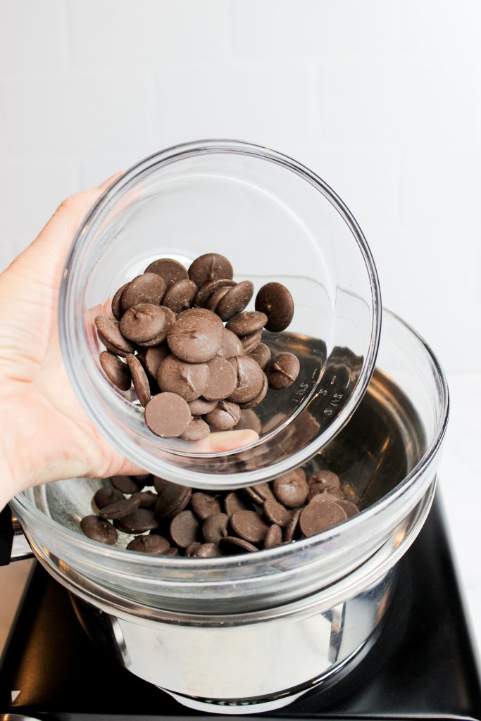 Chocolate wafers being poured into a double boiler