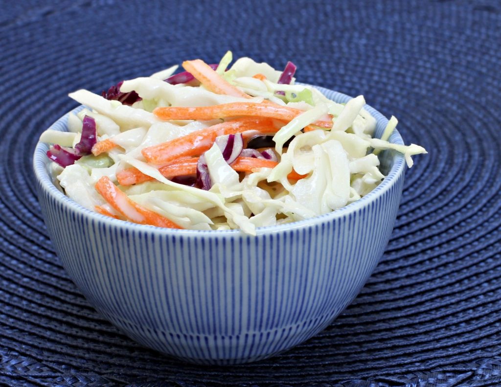 coleslaw in a blue bowl with a blue background