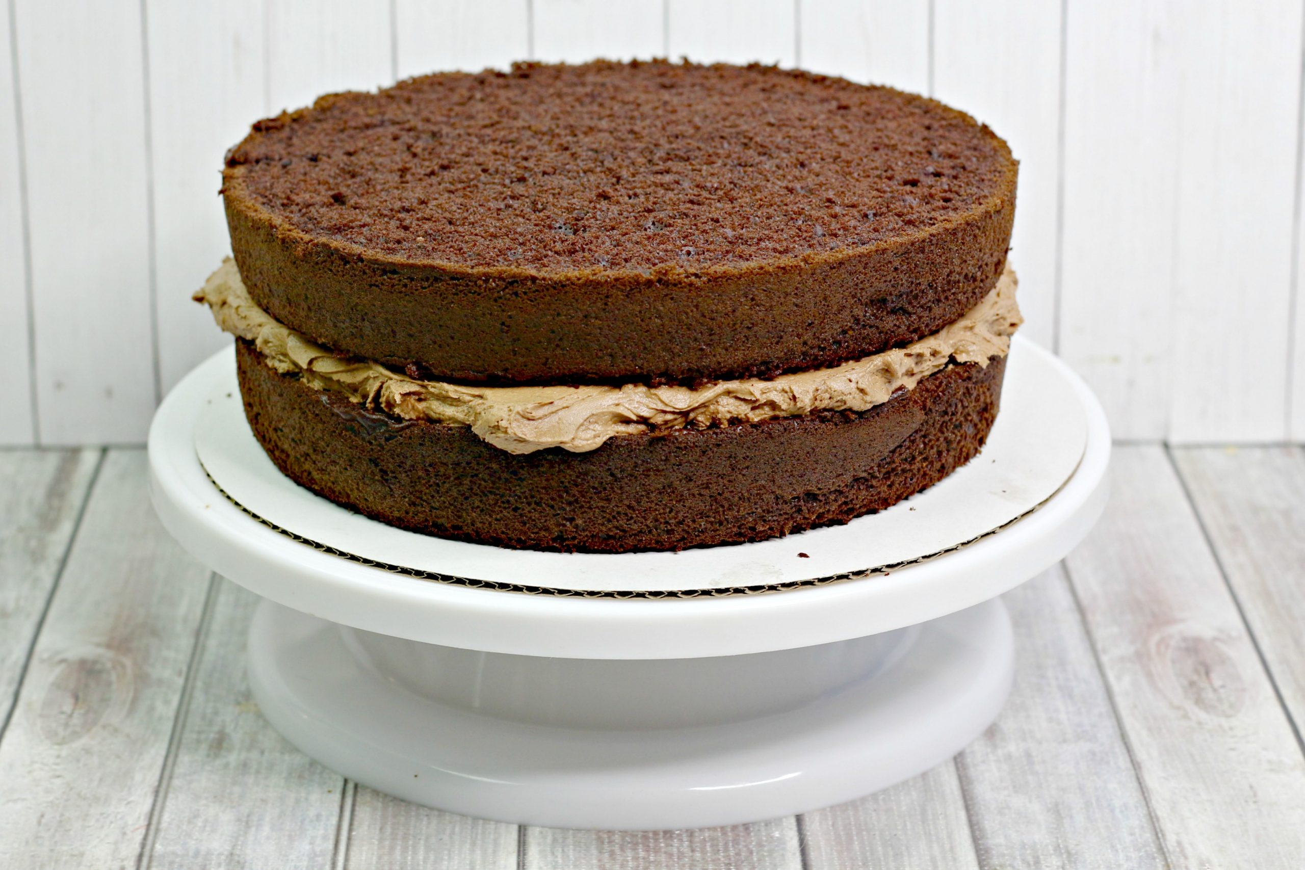 Two layers of the cake with chocolate frosting in the middle.