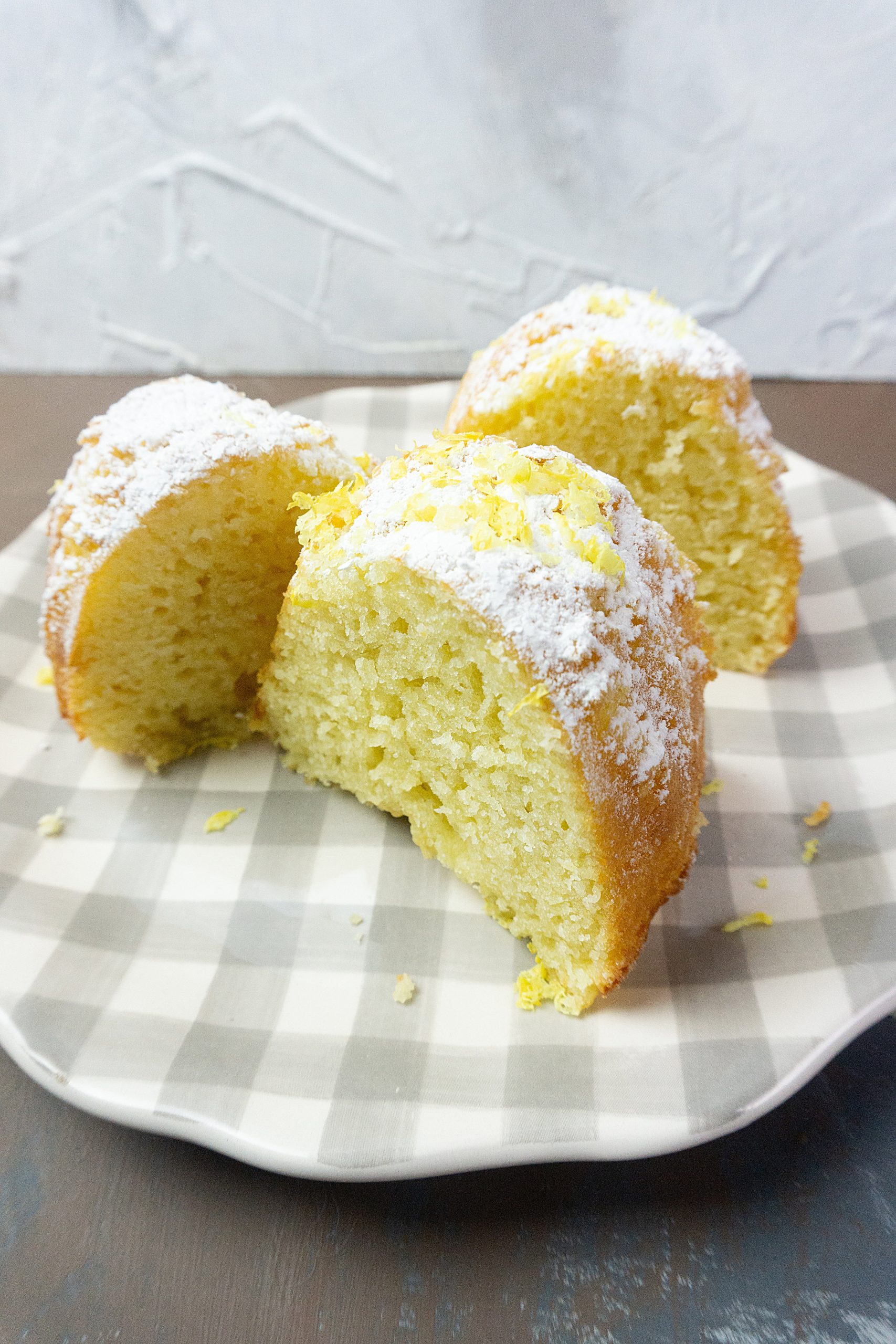 Meyer Lemon Bundt Cake on a brown table with a white background.