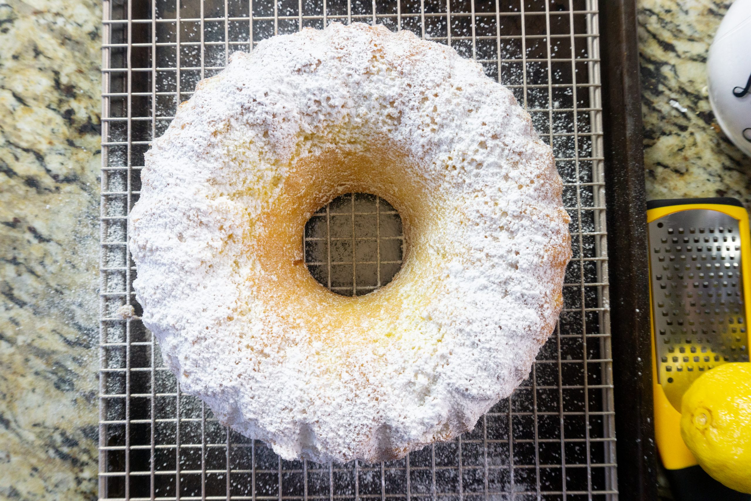 Dusting the Meyer Lemon Bundt Cake with sifted powdered sugar.