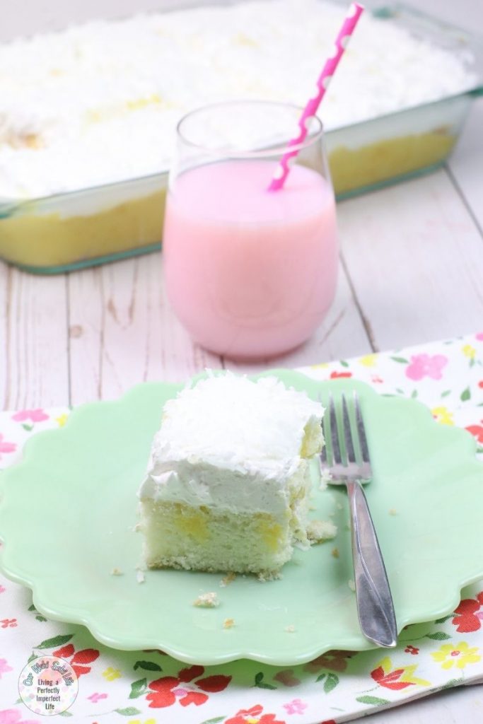 coconut poke cake on a serving dish with a fork.