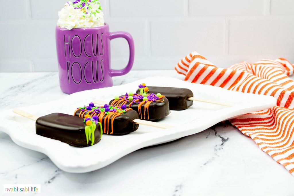 The Cakesicles on a platter with a Hocus Pocus Mug in the background.