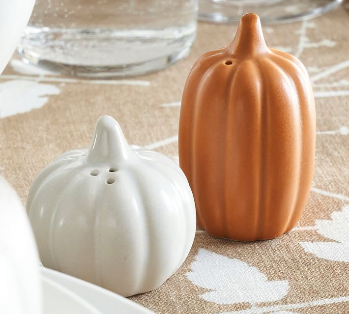 Two pumpkin salt and pepper shakers on a table.