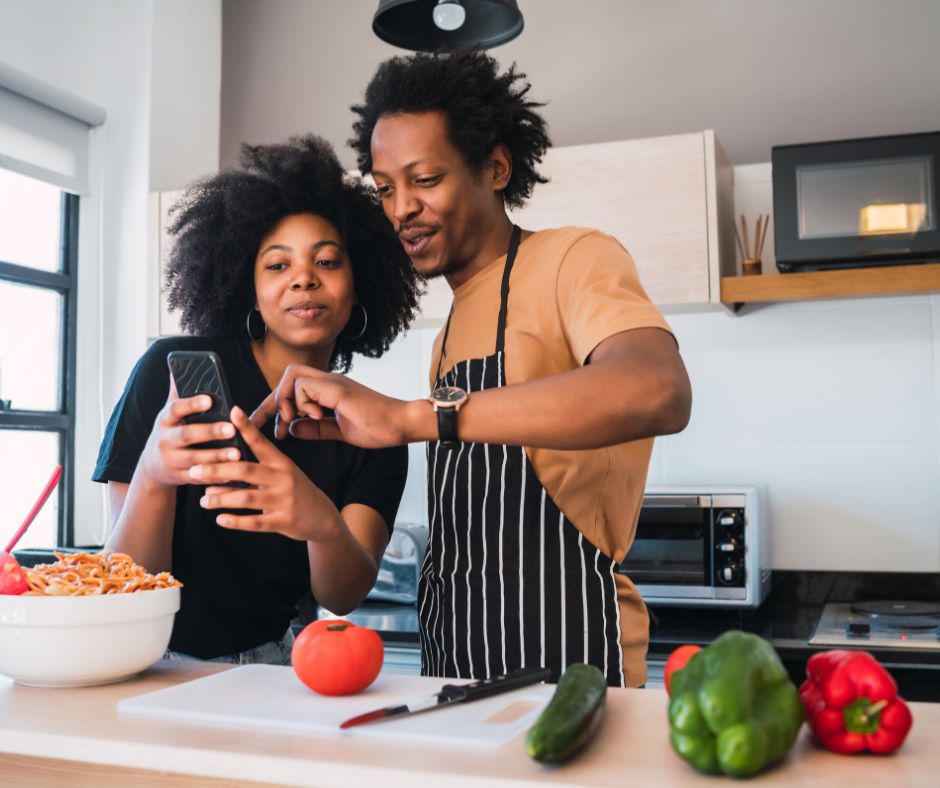 couple looking at phone with cooking