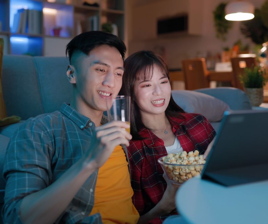 couple watching tv with popcorn