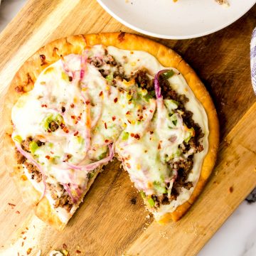 Ground beef pizza on a wooden board