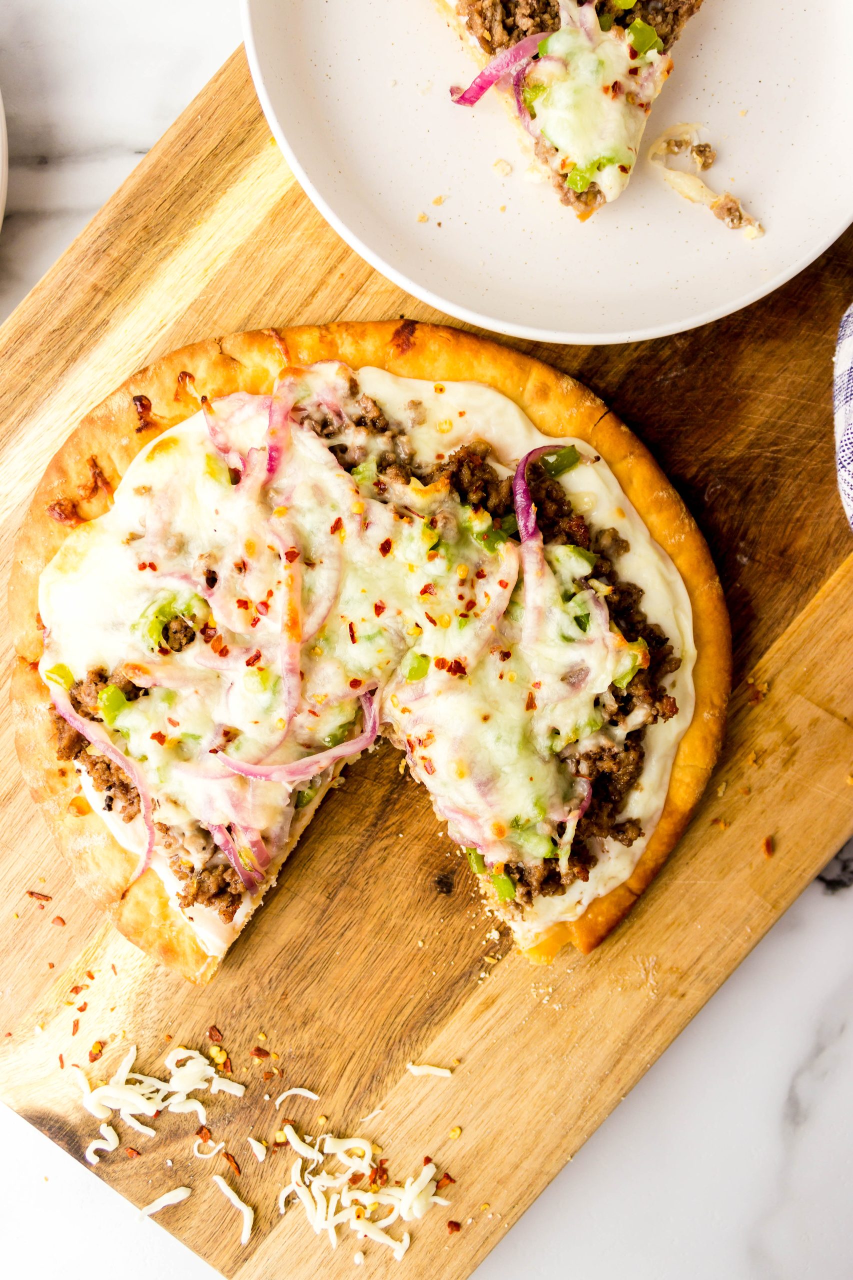 Ground beef pizza on a wooden board