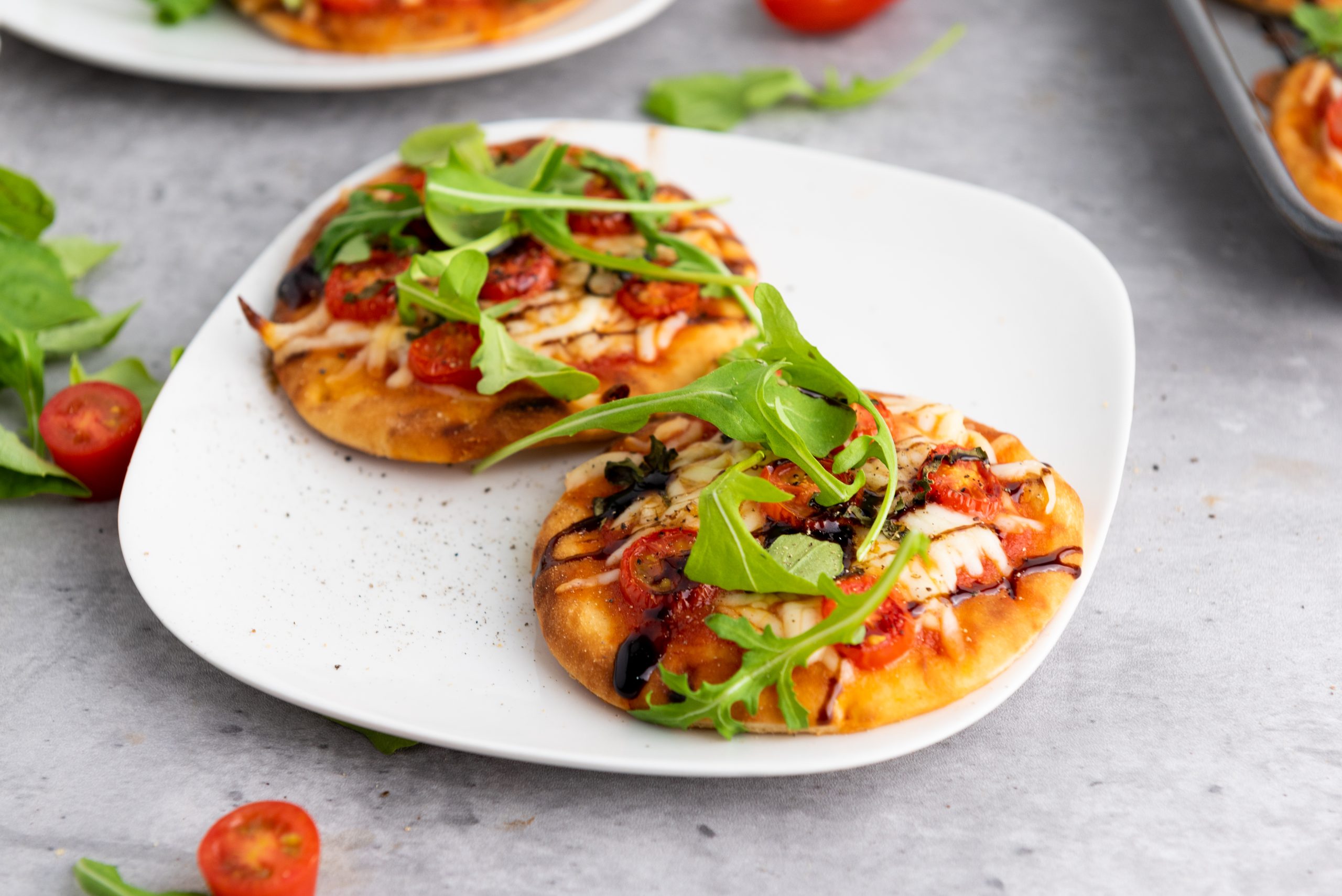 mini caprese pizza on a white plate