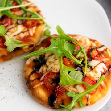 mini caprese pizzas on a white plate