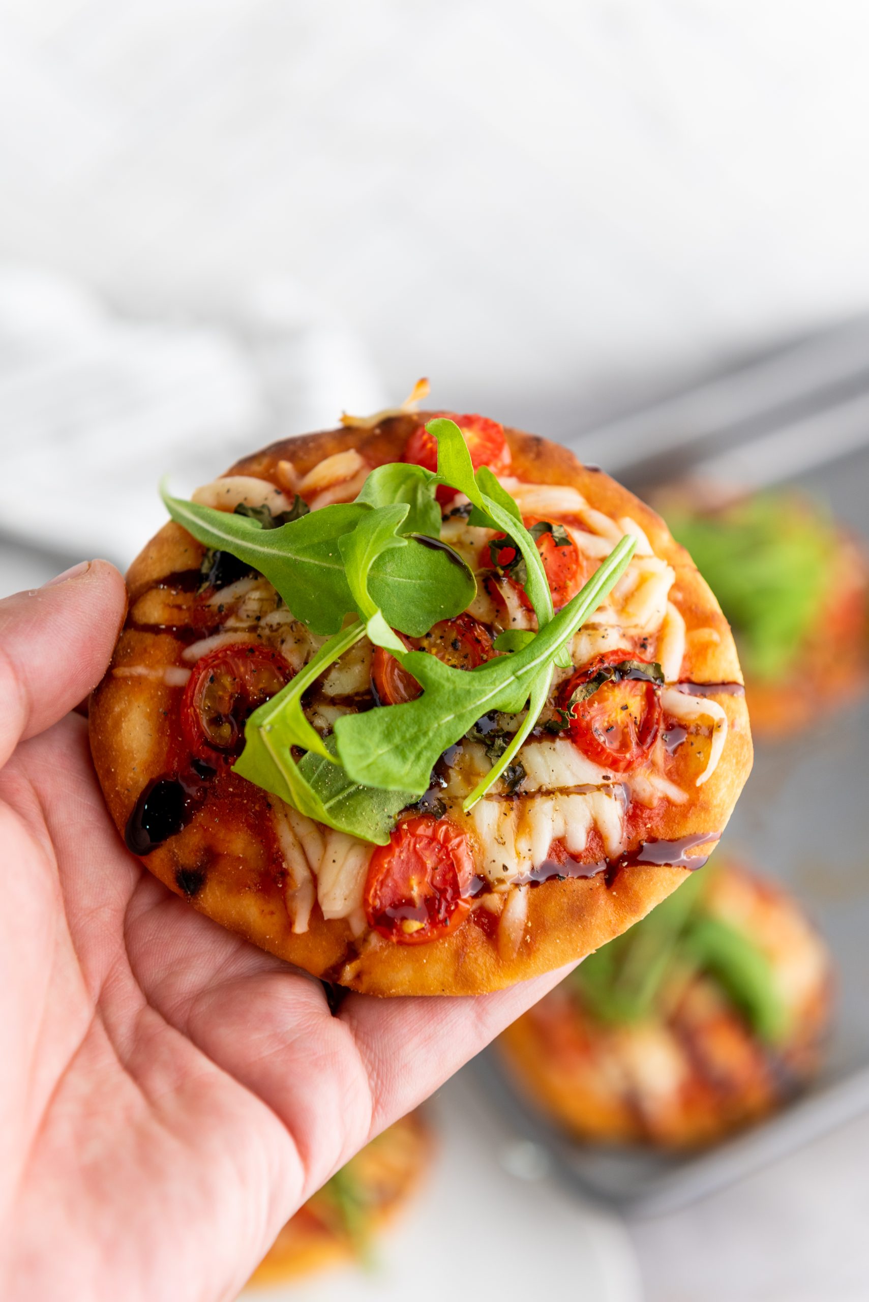 mini caprese pizza in a hand