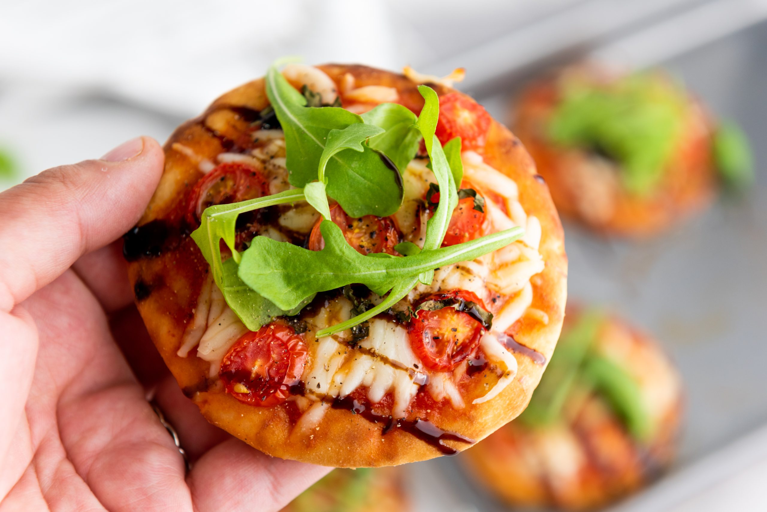 caprese pizza in a hand