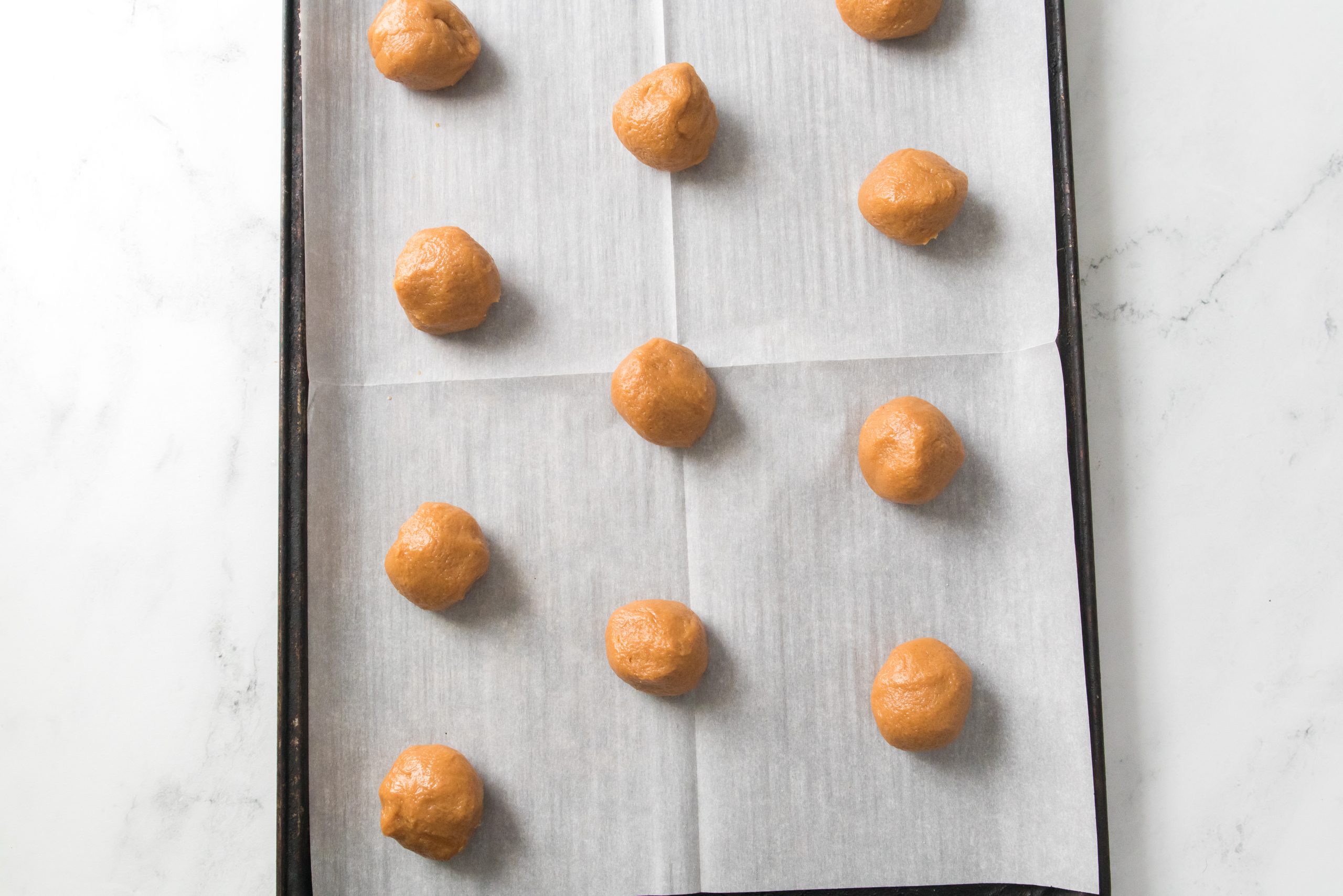 cookie dough balls on a baking sheet