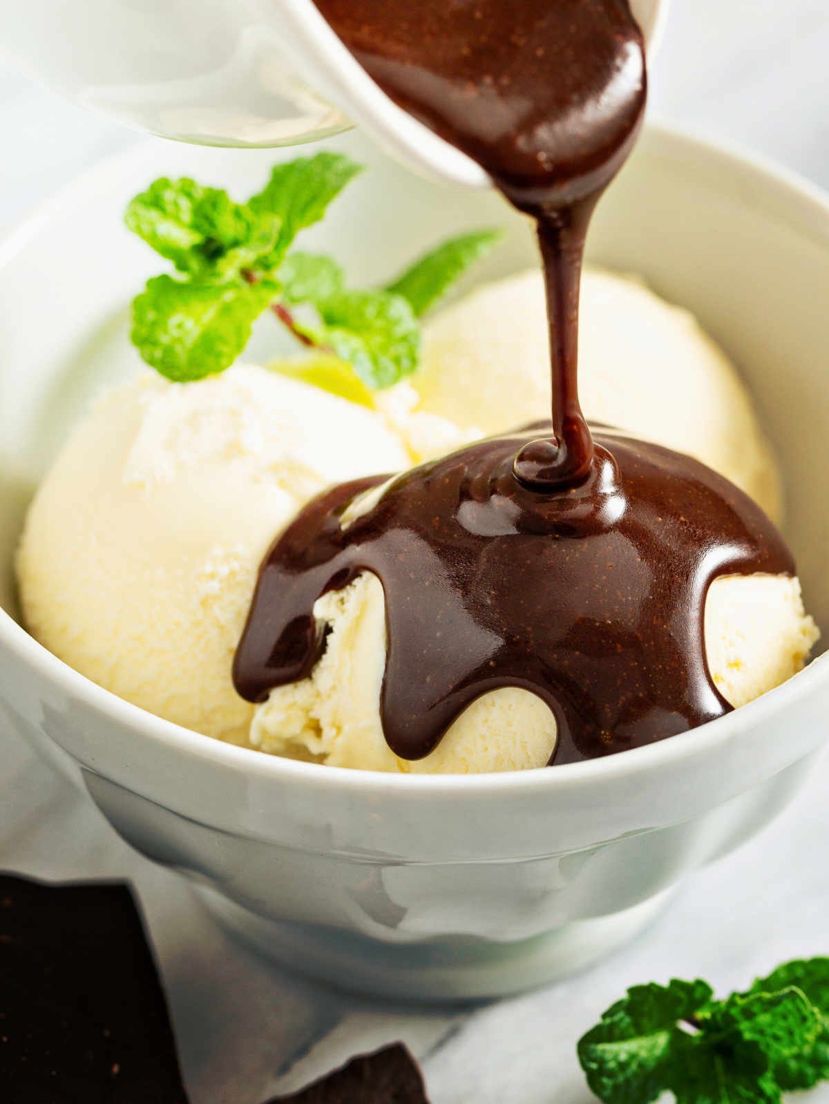 chocolate syrup being poured over ice crema