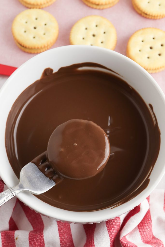 cracker cookies on a fork, dunked into chocolate