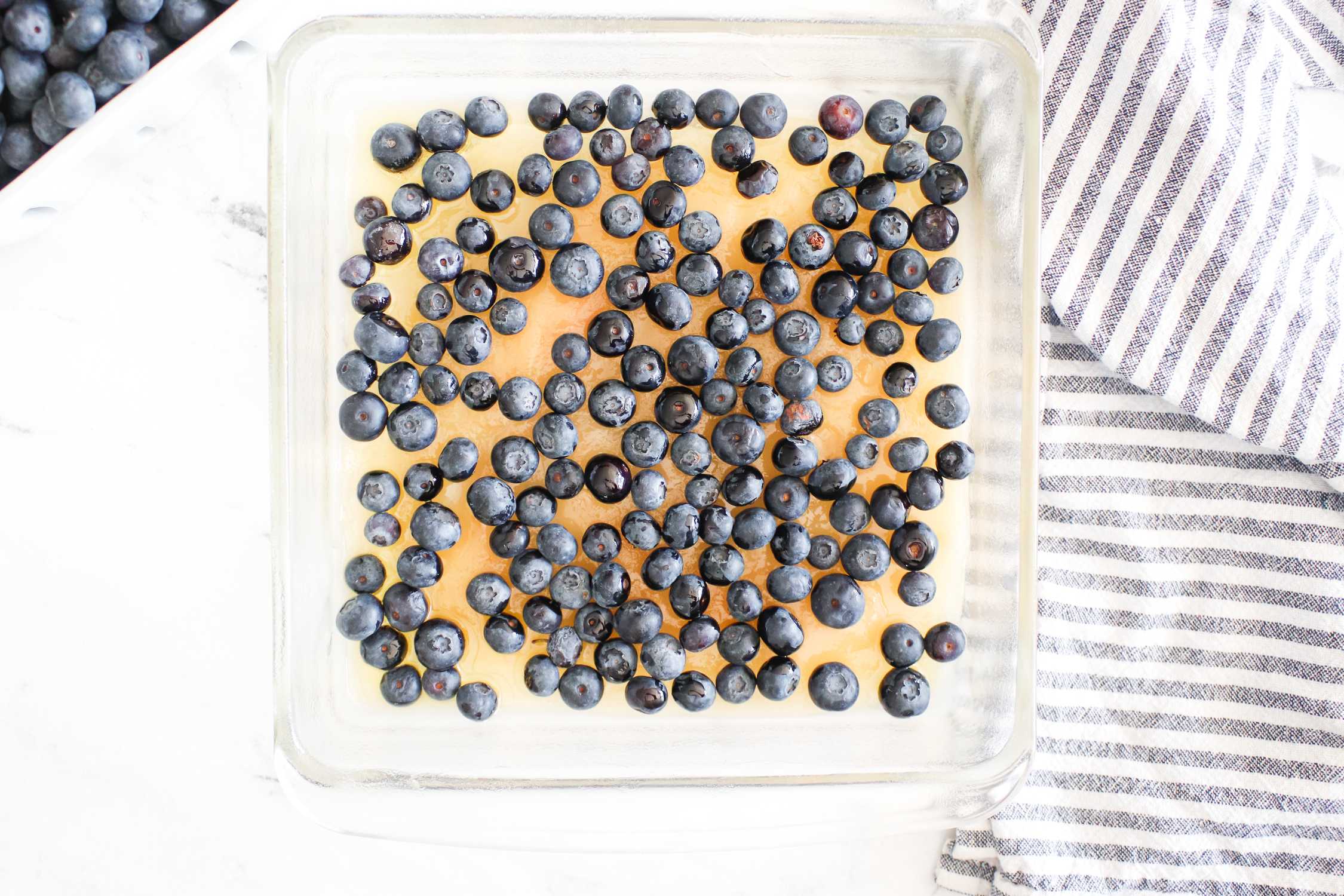 adding blueberries to the cake pan