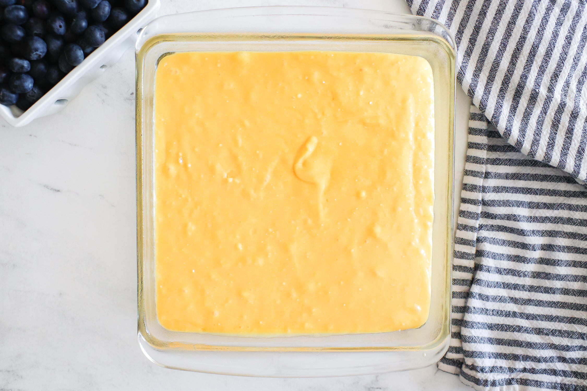 Adding cake batter to the pan