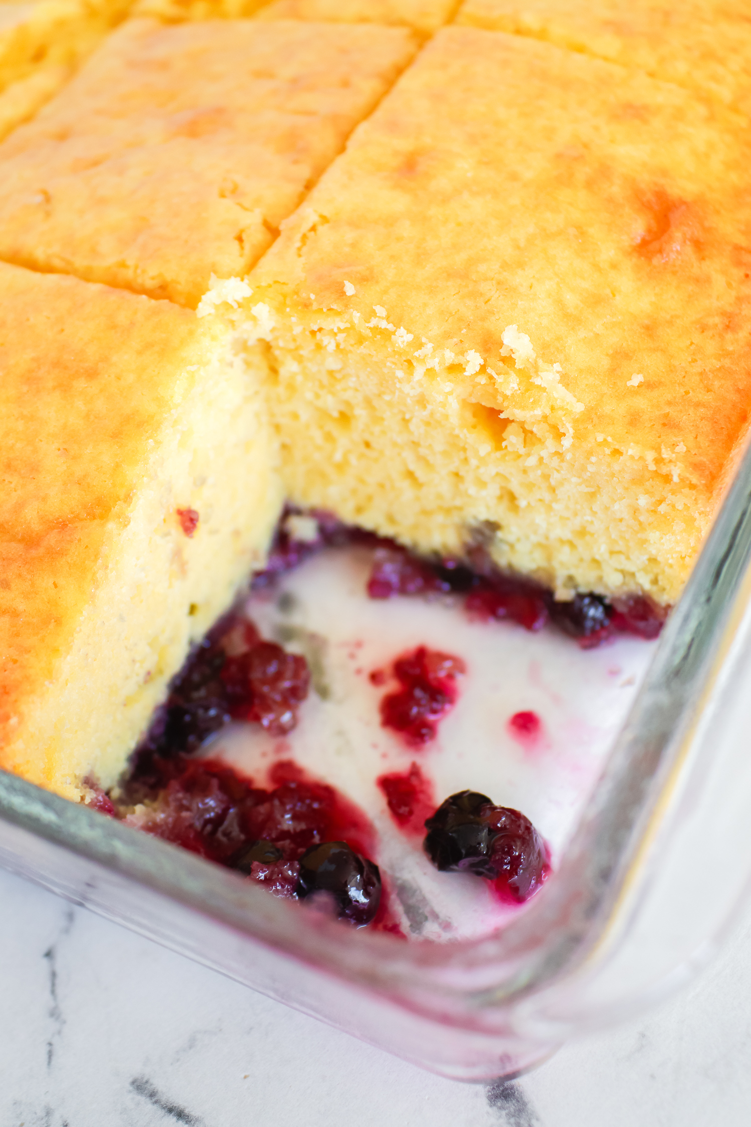 blueberry lemon cake in a clear cake pan