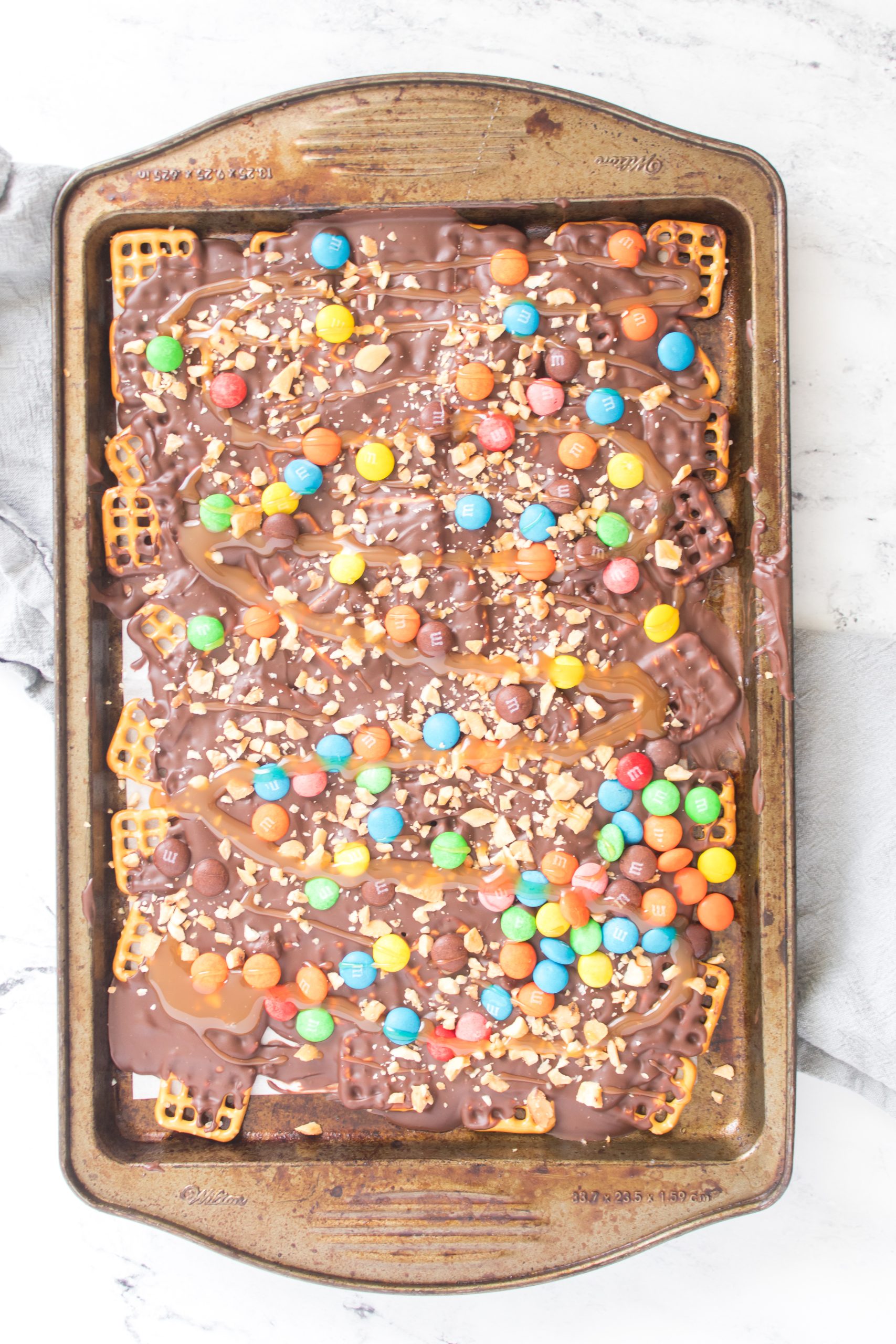 caramel drizzled over the tray with the pretzel, chocolate, m&m, and peanuts