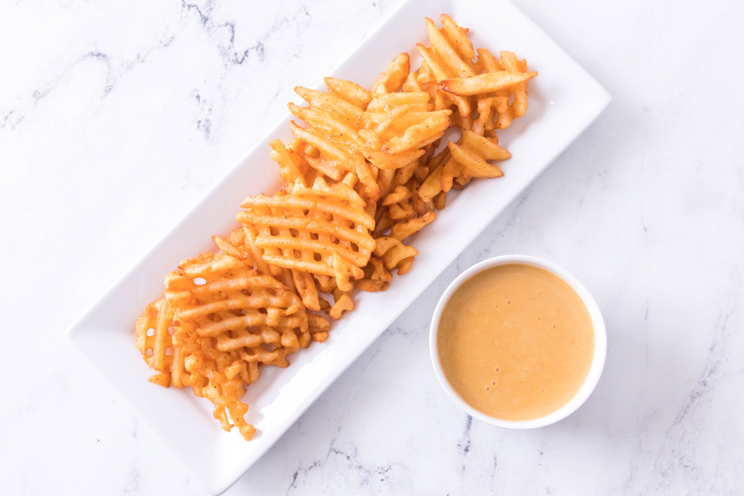 Copycat Chick Fil a Sauce with a plate of waffle fries