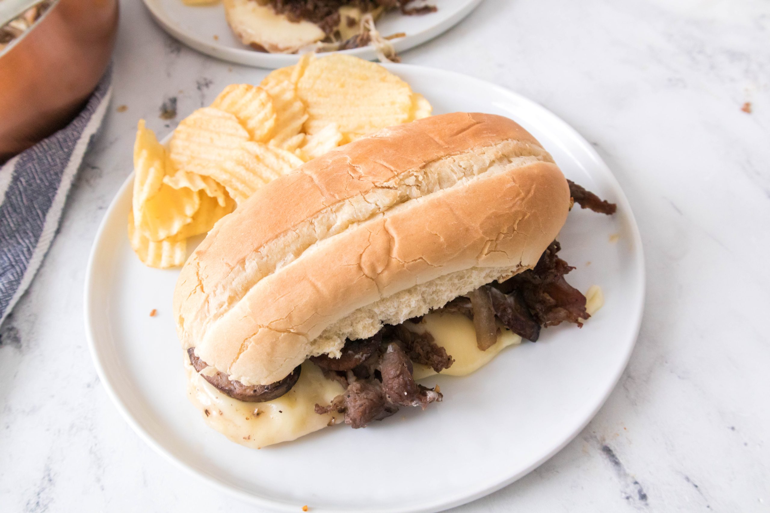 overhead of cheesesteak on a white plate