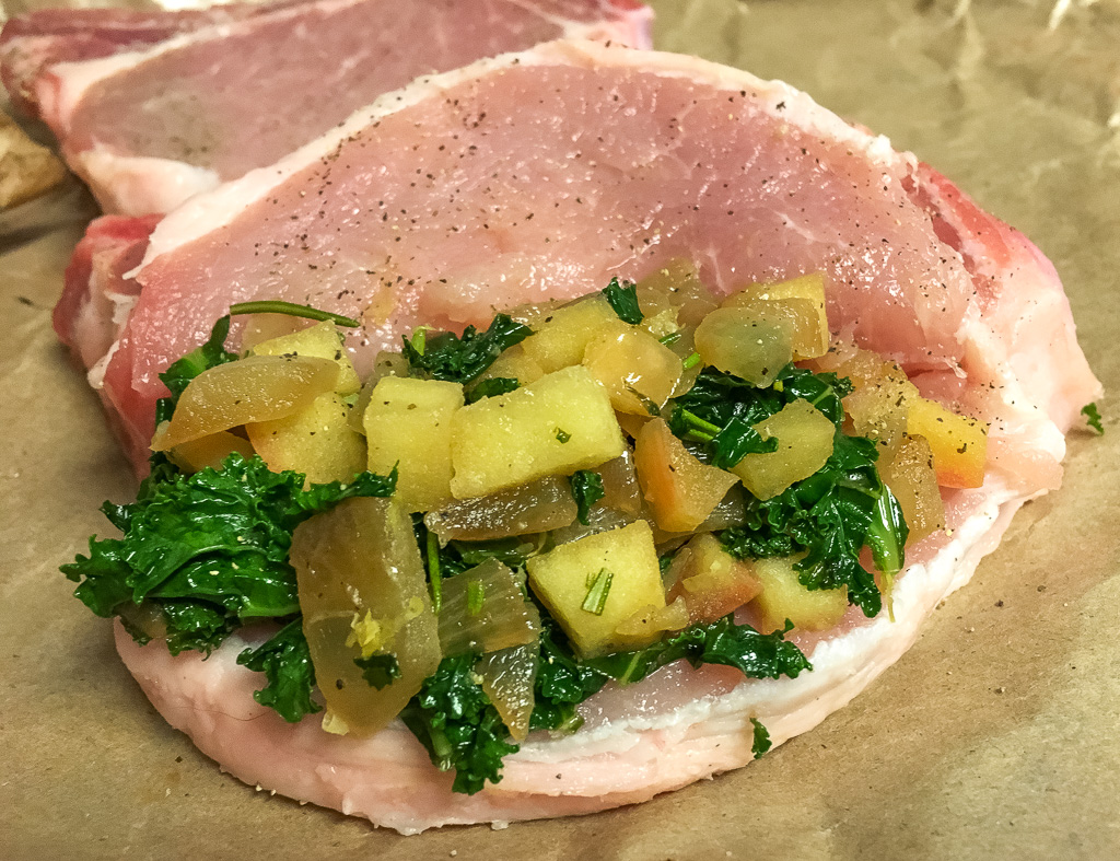 raw pork chop with kale, apple, cinnamon, lemon zest, and fresh rosemary