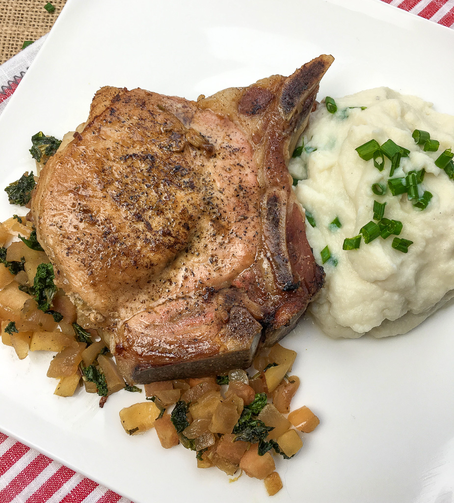 cooked pork chop with mashed potatoes next to it 