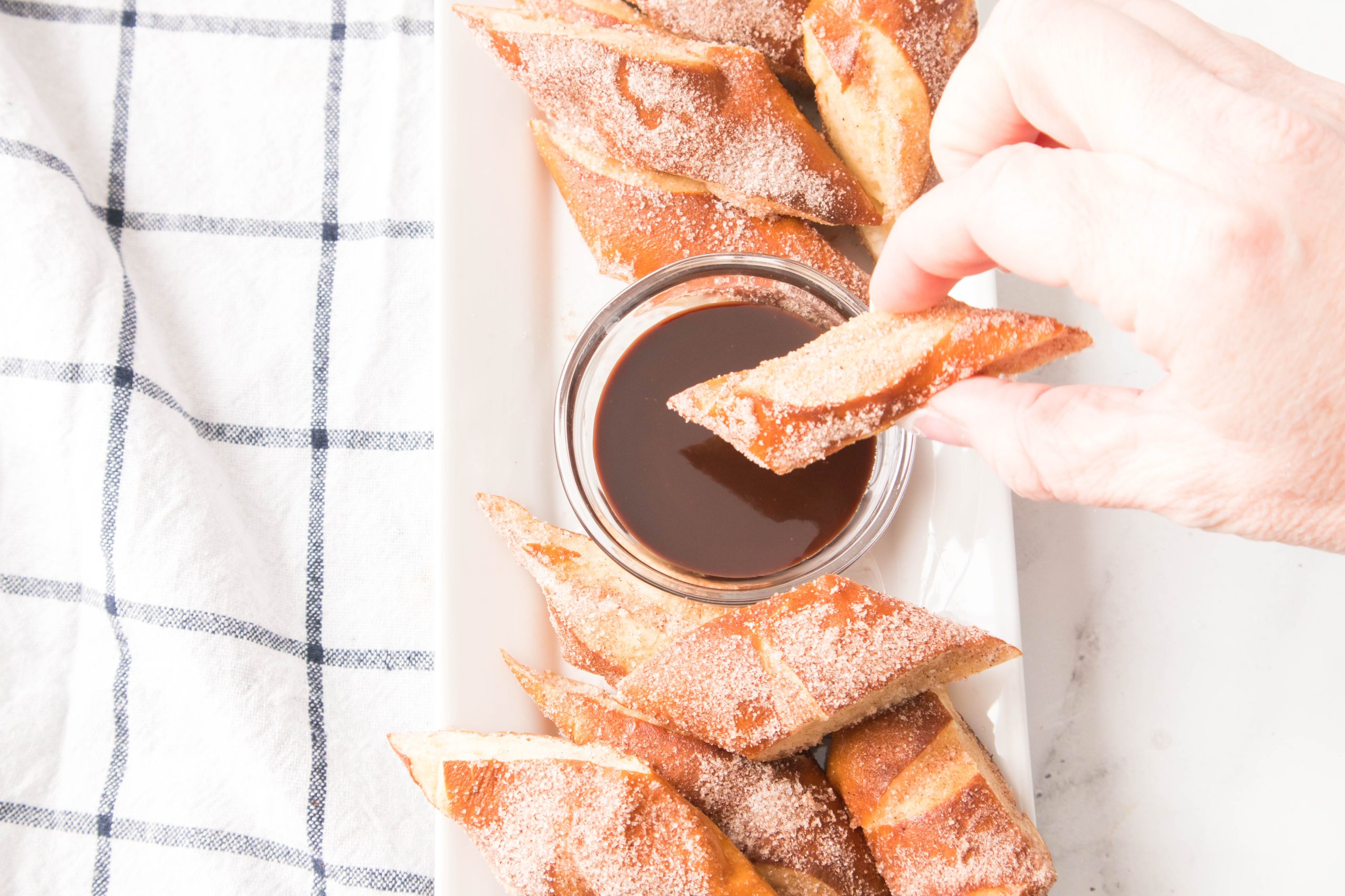 dipping Air Fryer Soft Pretzel Cinnamon Bites in chocolate sauce