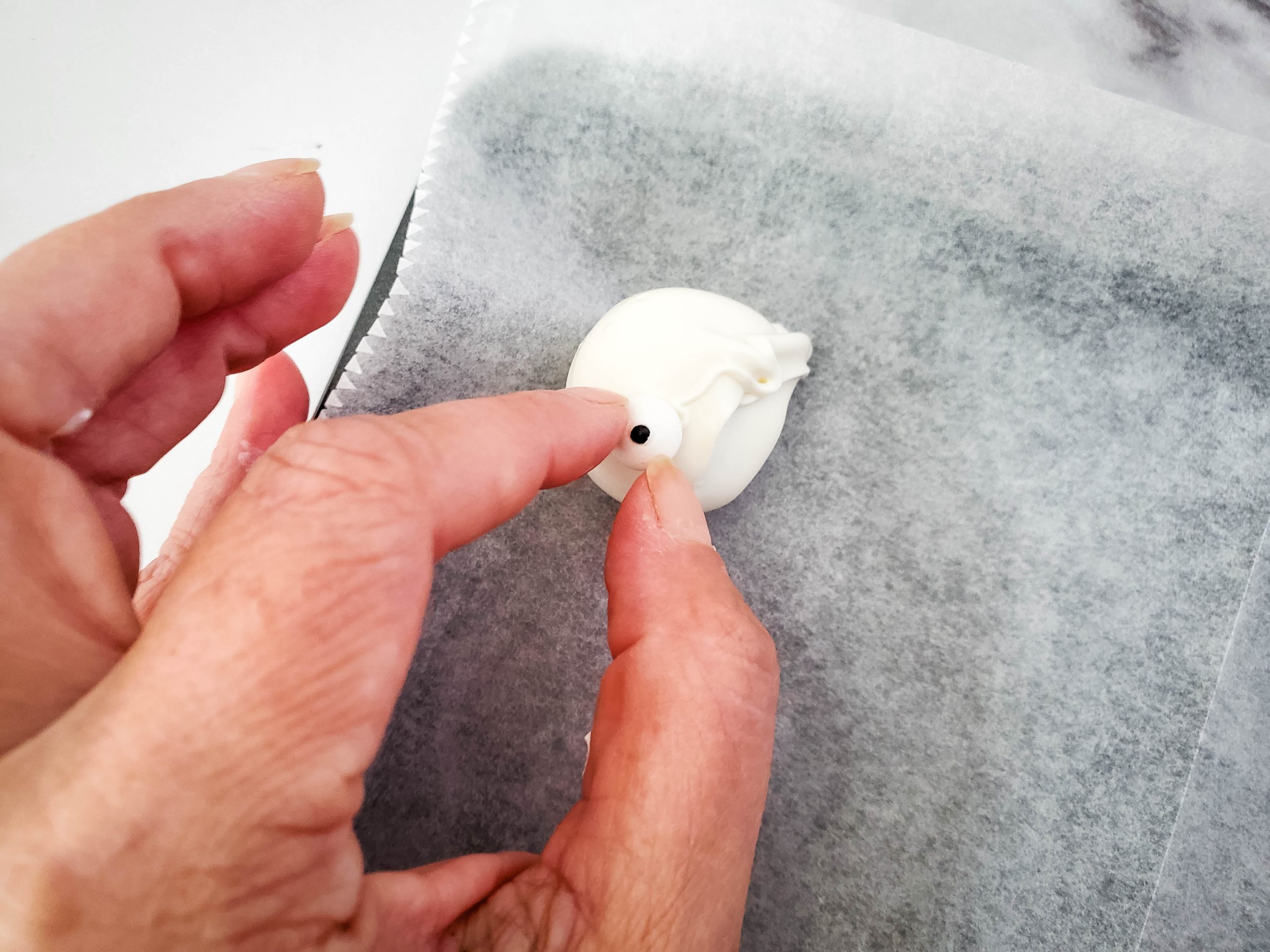 Adding the candy eyes to the oreo mummy balls