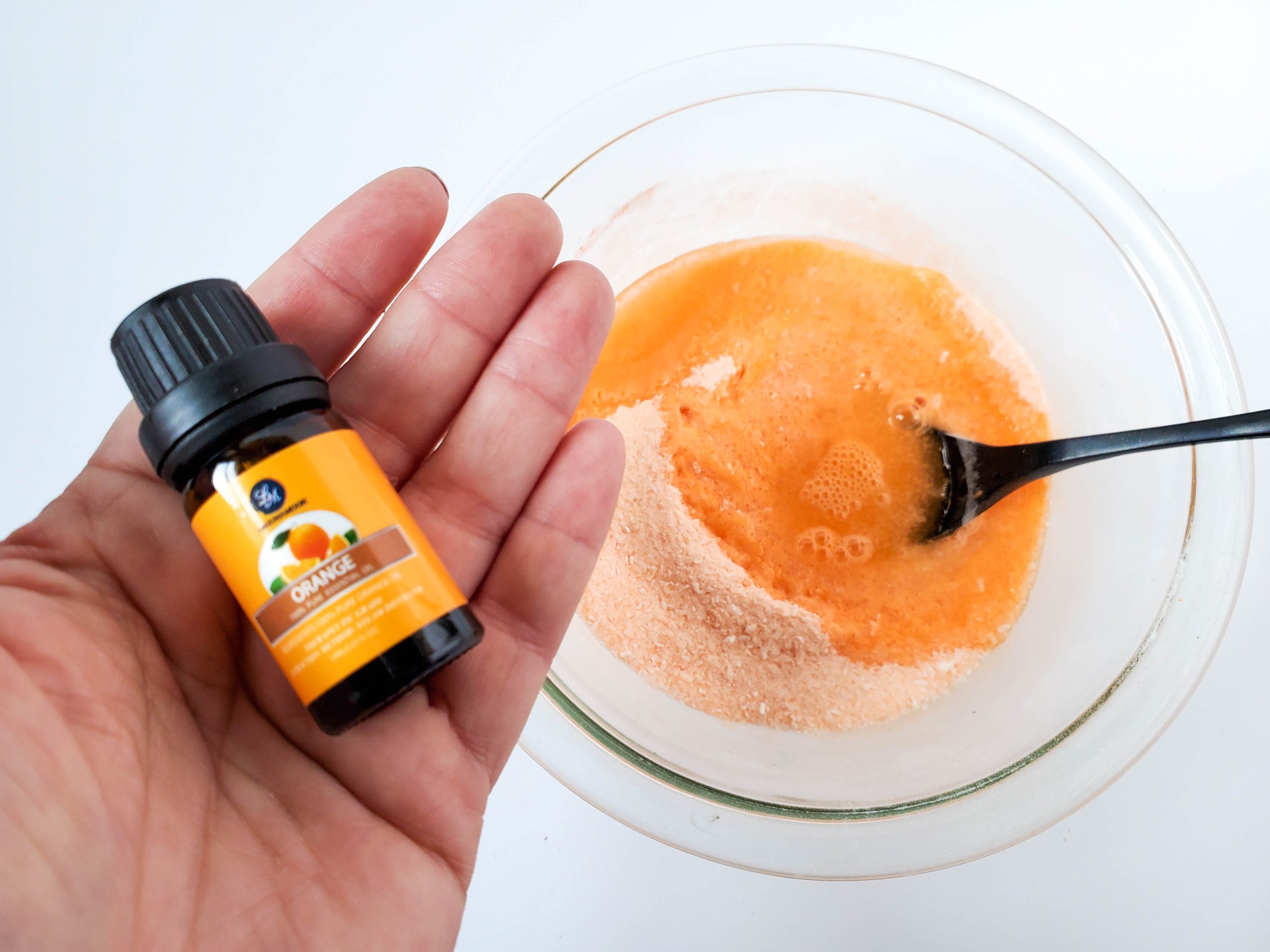 adding the essential oils to the sweet orange shower steamer