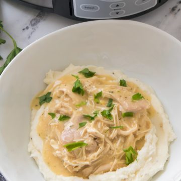 chicken and gravy in a crock pot recipe in a white bowl